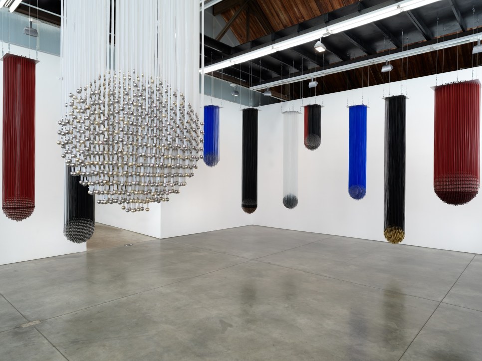 gallery installation of hanging abstract sculptures made out of plastic and beads