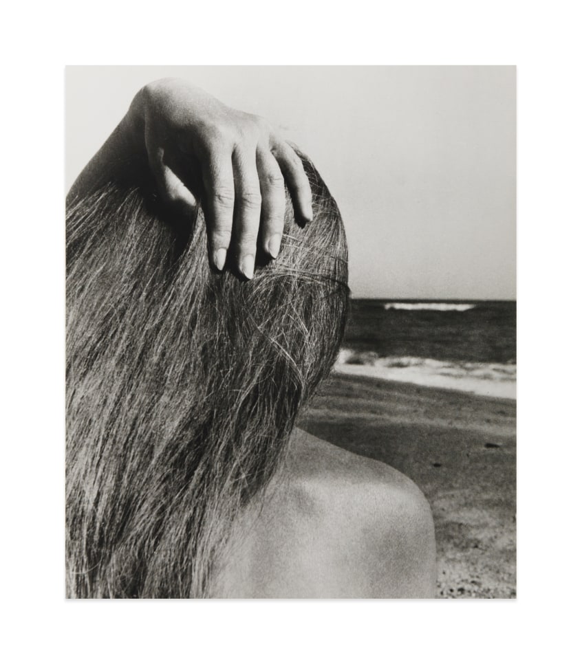 Black and white photograph by Bill Brandt showing the back of the head of a female figure on the beach 