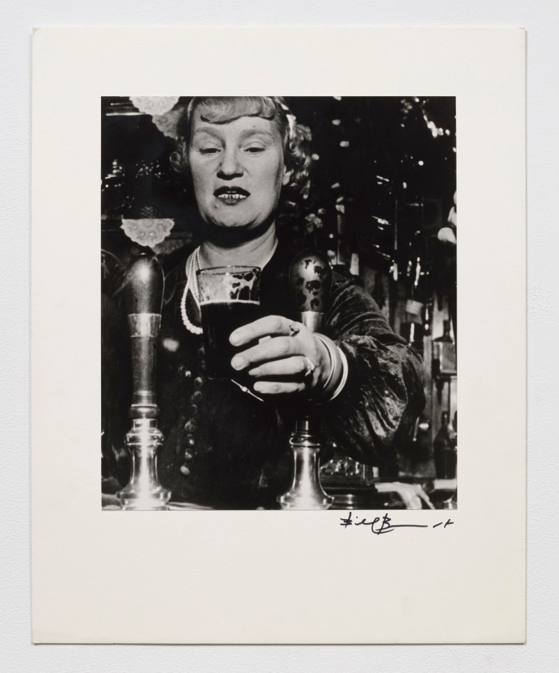 Black and white photographic by Bill Brandt featuring a woman serving a cocktail