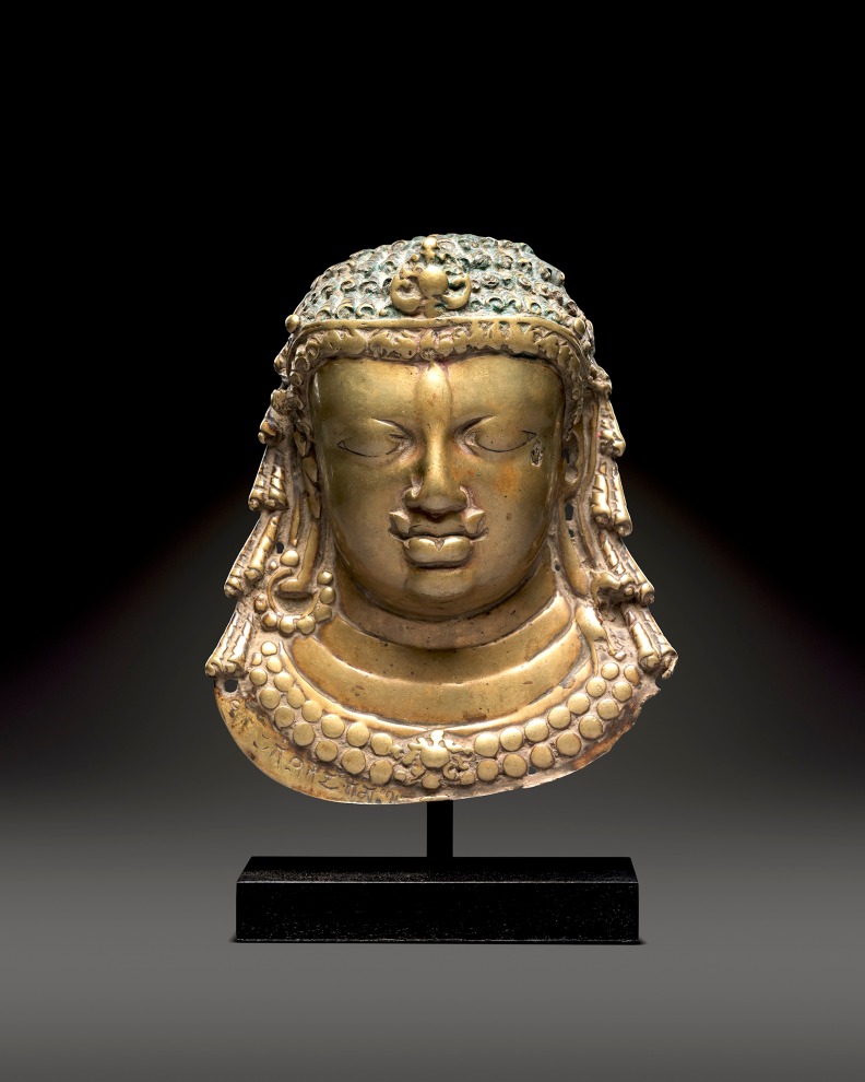 This brass relief represents the Hindu god Shiva, the facial features worn by the repeated use of ritual unguents